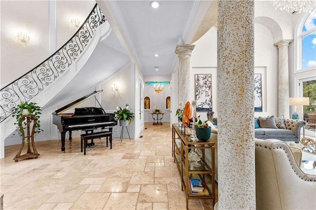 foyer entrance featuring ornate columns and crown molding