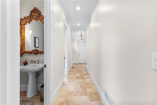 hallway featuring ornamental molding and sink