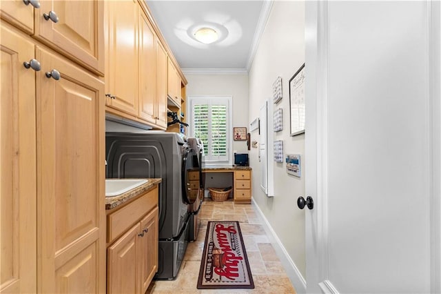 clothes washing area with cabinets, crown molding, and independent washer and dryer