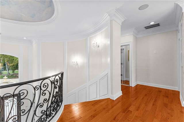 hall with wood-type flooring and crown molding