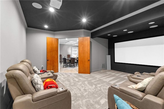 carpeted home theater featuring crown molding