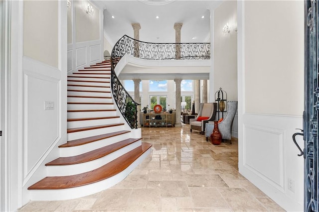 entryway featuring a towering ceiling and ornate columns