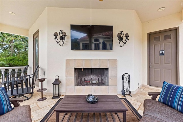 living room with lofted ceiling and a tiled fireplace