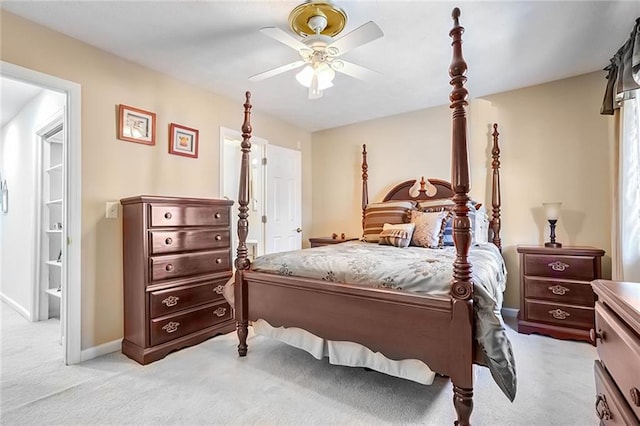 bedroom featuring ensuite bathroom, light colored carpet, and ceiling fan