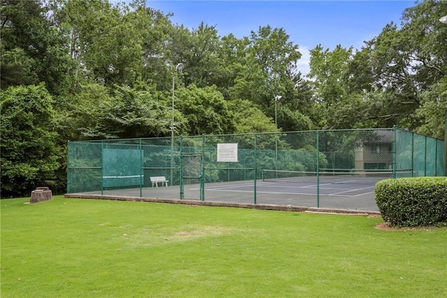 view of tennis court featuring a yard