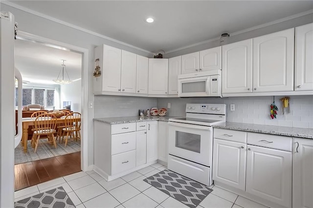 kitchen with tasteful backsplash, light stone countertops, white cabinets, and white appliances