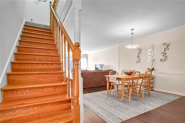 stairway with hardwood / wood-style floors and ornamental molding