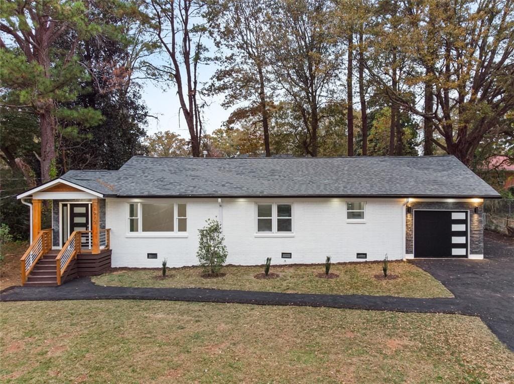 ranch-style home with a garage and a front yard