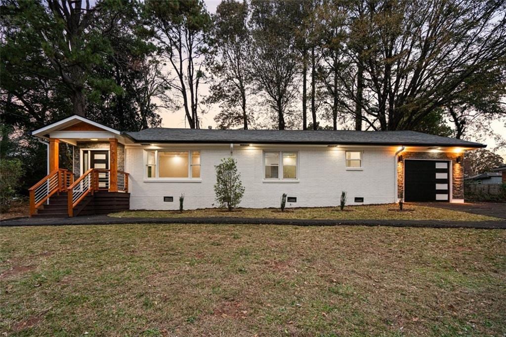 view of front facade with a garage and a lawn