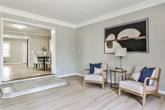 living area with wood finished floors, ornamental molding, and baseboards