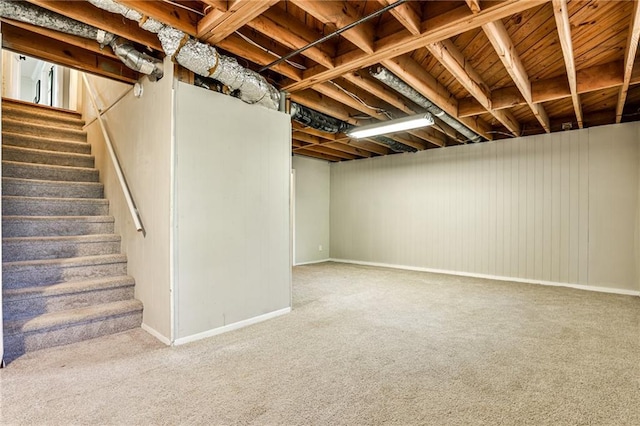 finished basement featuring baseboards, stairs, and carpet