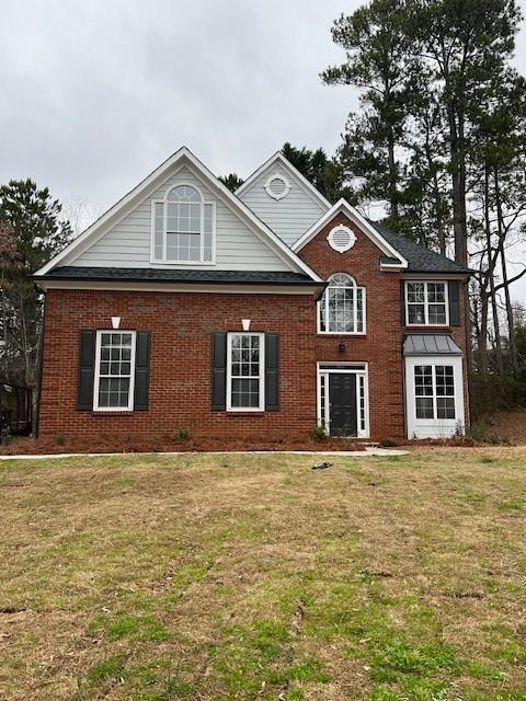 view of front of property with brick siding and a front yard