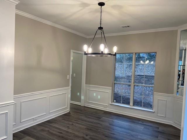 unfurnished dining area featuring visible vents, ornamental molding, wainscoting, dark wood-style floors, and an inviting chandelier