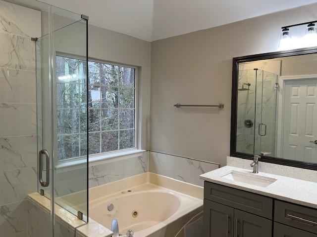 full bath featuring a shower stall, a whirlpool tub, and vanity