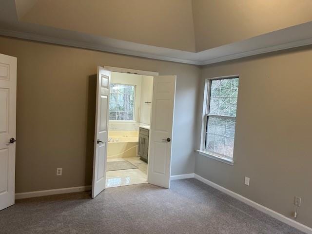 unfurnished bedroom featuring crown molding, ensuite bathroom, carpet flooring, and baseboards