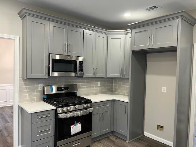 unfurnished dining area with baseboards, dark wood-style flooring, visible vents, and an inviting chandelier