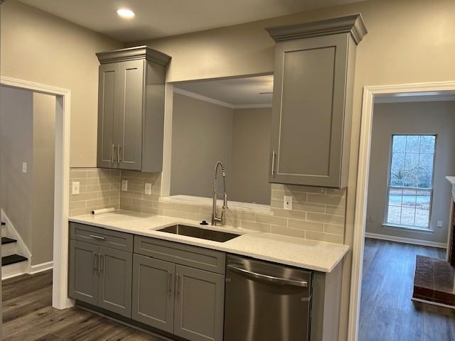 kitchen with appliances with stainless steel finishes, dark wood finished floors, a sink, and gray cabinetry