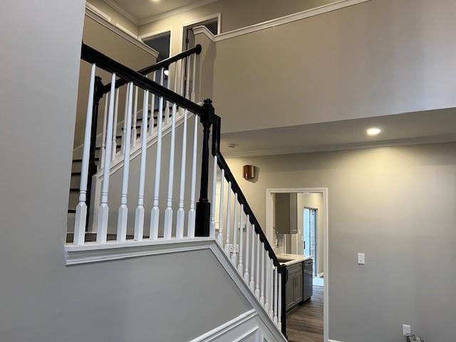 staircase featuring baseboards, wood finished floors, and recessed lighting