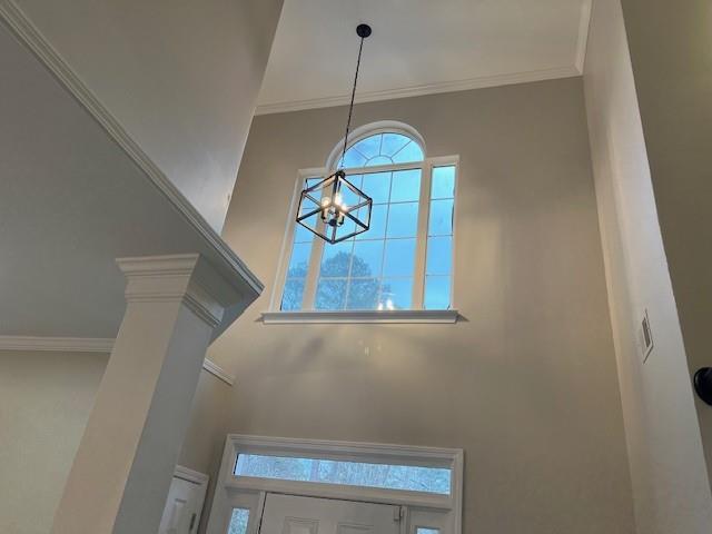 details featuring an inviting chandelier and ornamental molding