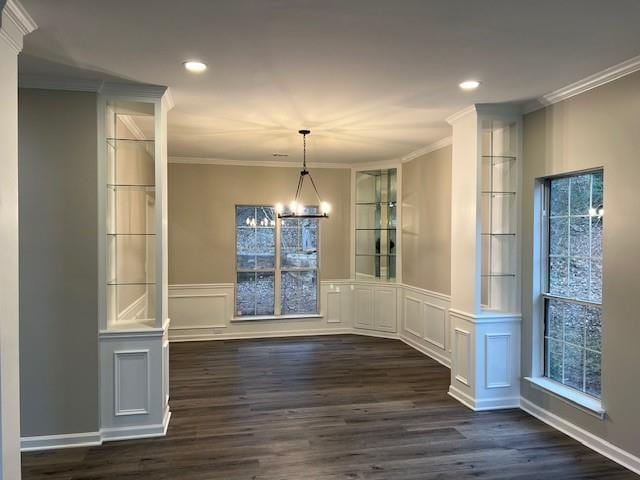 unfurnished dining area featuring ornamental molding, recessed lighting, dark wood-style flooring, and a chandelier