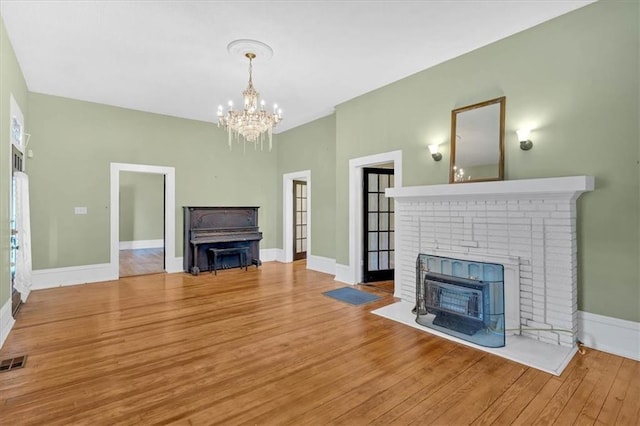226 Noyes St, Cedartown, GA 30125 - unfurnished living room featuring a fireplace, a chandelier, and wood finished floors