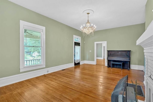 226 Noyes St, Cedartown, GA 30125 - unfurnished living room with a chandelier, hardwood / wood-style flooring, and a fireplace
