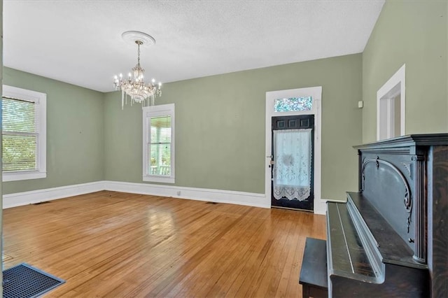 226 Noyes St, Cedartown, GA 30125 - entrance foyer featuring hardwood / wood-style flooring, healthy amount of natural light, a chandelier, and a textured ceiling
