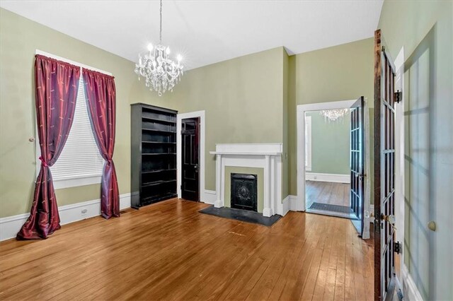 226 Noyes St, Cedartown, GA 30125 - unfurnished living room featuring a chandelier, hardwood / wood-style floors, and a fireplace