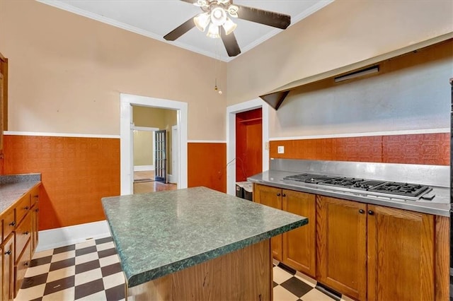 226 Noyes St, Cedartown, GA 30125 - kitchen with light flooring, open shelves, stainless steel gas cooktop, brown cabinets, and a wainscoted wall