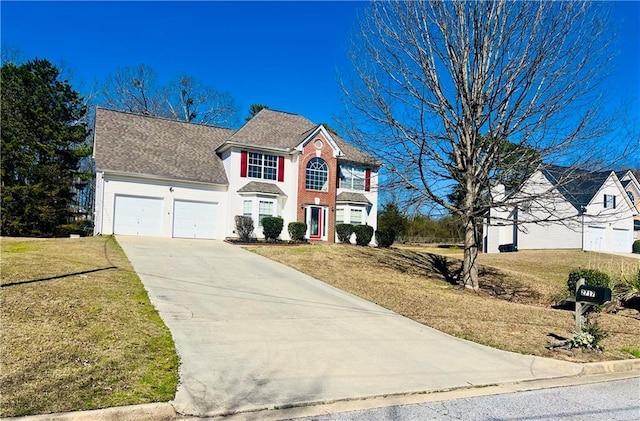 colonial house with an attached garage, brick siding, concrete driveway, and a front yard