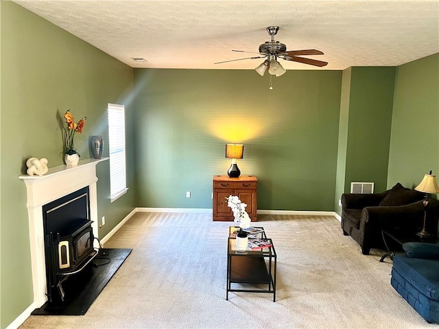 living room with visible vents, light carpet, ceiling fan, a textured ceiling, and baseboards