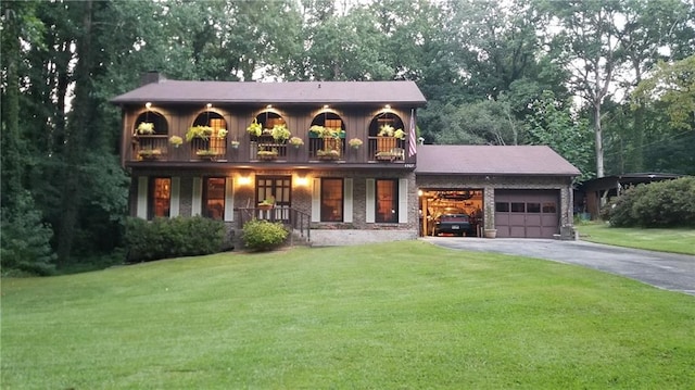 view of front facade featuring a balcony, a garage, and a front lawn