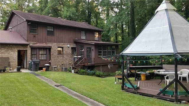 rear view of property featuring a deck and a yard