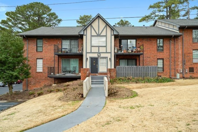 view of front facade featuring a balcony and brick siding