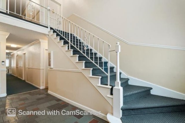 stairs featuring baseboards and a towering ceiling