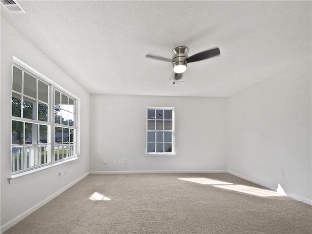 carpeted spare room with a textured ceiling and ceiling fan