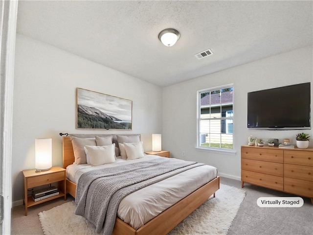 bedroom with carpet and a textured ceiling