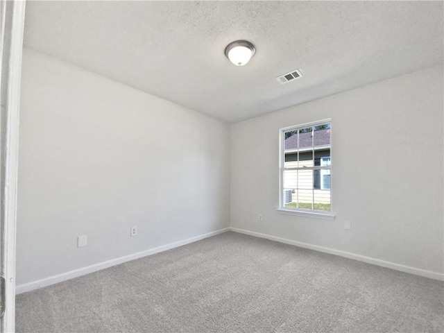 carpeted spare room with a textured ceiling