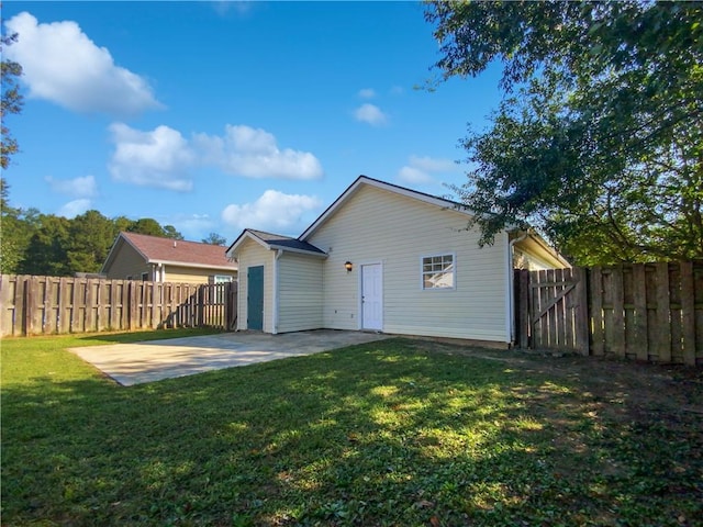 rear view of house featuring a patio and a lawn