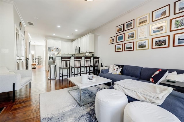 living room with dark hardwood / wood-style floors and ornamental molding