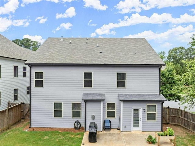 rear view of property with a lawn and a patio