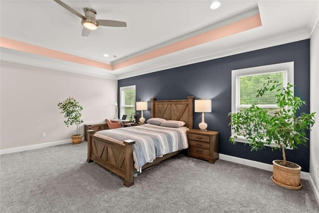 carpeted bedroom featuring ornamental molding, ceiling fan, and a tray ceiling