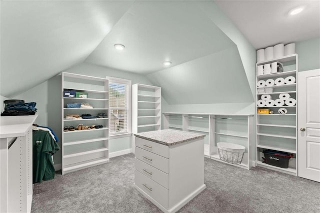 spacious closet with light colored carpet and vaulted ceiling