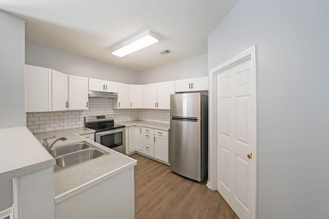 kitchen with light wood-type flooring, sink, white cabinetry, appliances with stainless steel finishes, and backsplash