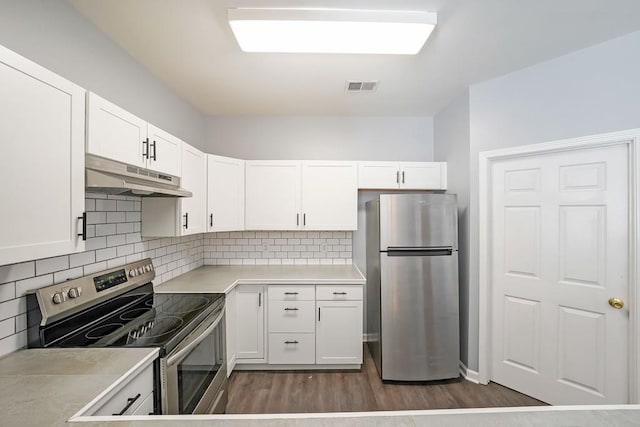 kitchen featuring decorative backsplash, white cabinets, appliances with stainless steel finishes, and dark hardwood / wood-style flooring