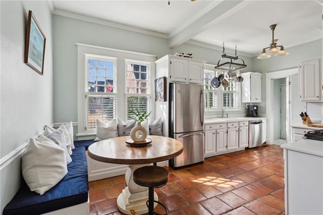 kitchen with stainless steel appliances, hanging light fixtures, a wealth of natural light, and white cabinets