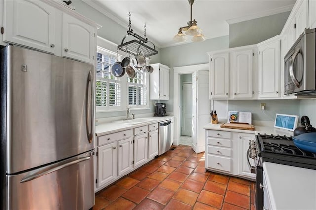 kitchen featuring sink, ornamental molding, appliances with stainless steel finishes, pendant lighting, and white cabinets