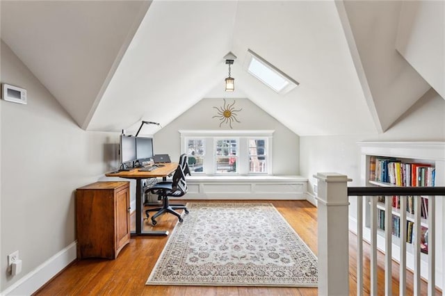 office featuring light hardwood / wood-style flooring and vaulted ceiling with skylight