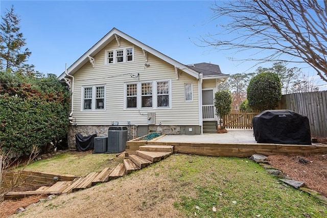 rear view of property featuring central AC, a patio area, and a lawn