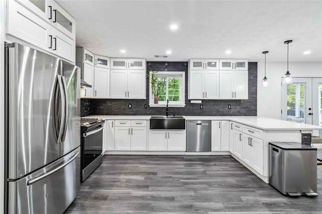 870 Underhill Ct, Sugar Hill, GA 30518 - kitchen featuring stainless steel appliances, a peninsula, a sink, dark wood-style flooring, and backsplash